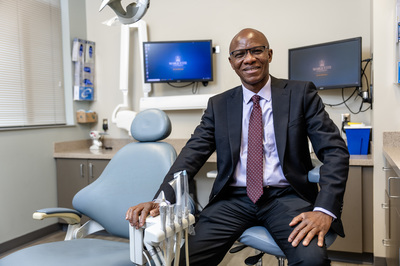 Dr. Christopher Okunseri sits in a dental office.