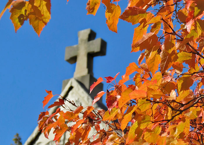 Cross at St. Joan of Arc Chapel amid autumn leaves