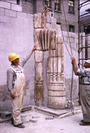 Two workers lift a stone in place as part of the Saint Joan of Arc Chapel reconstruction, 1966.