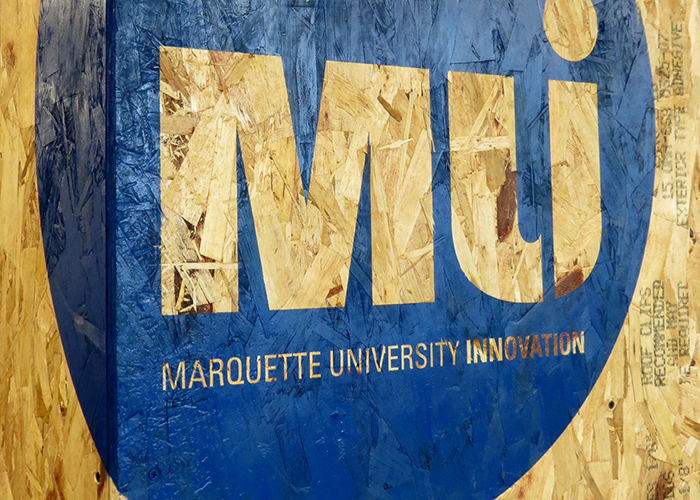 Marquette Innovation logo on wood wall.