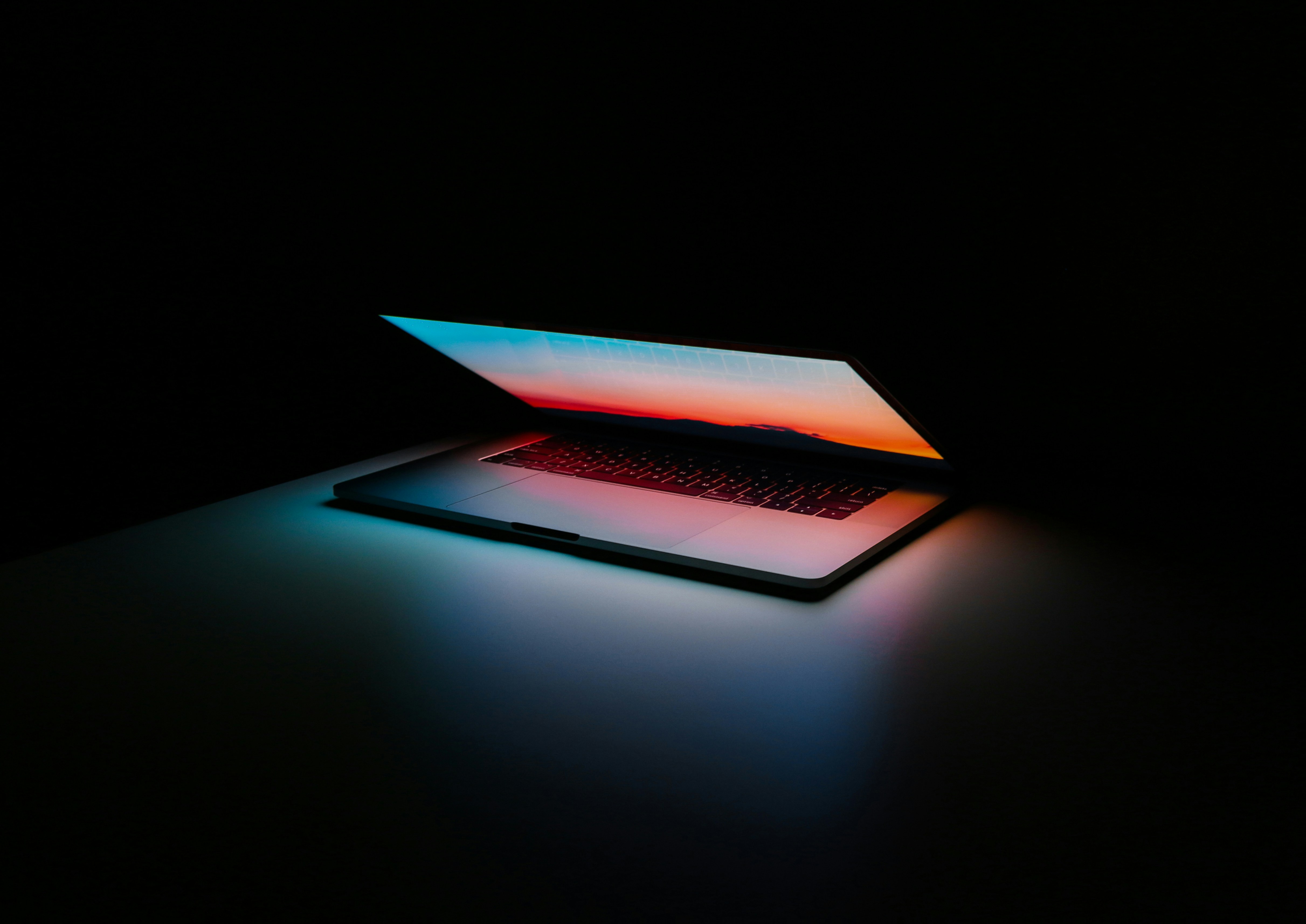 A laptop computer partially opened against a dark background.