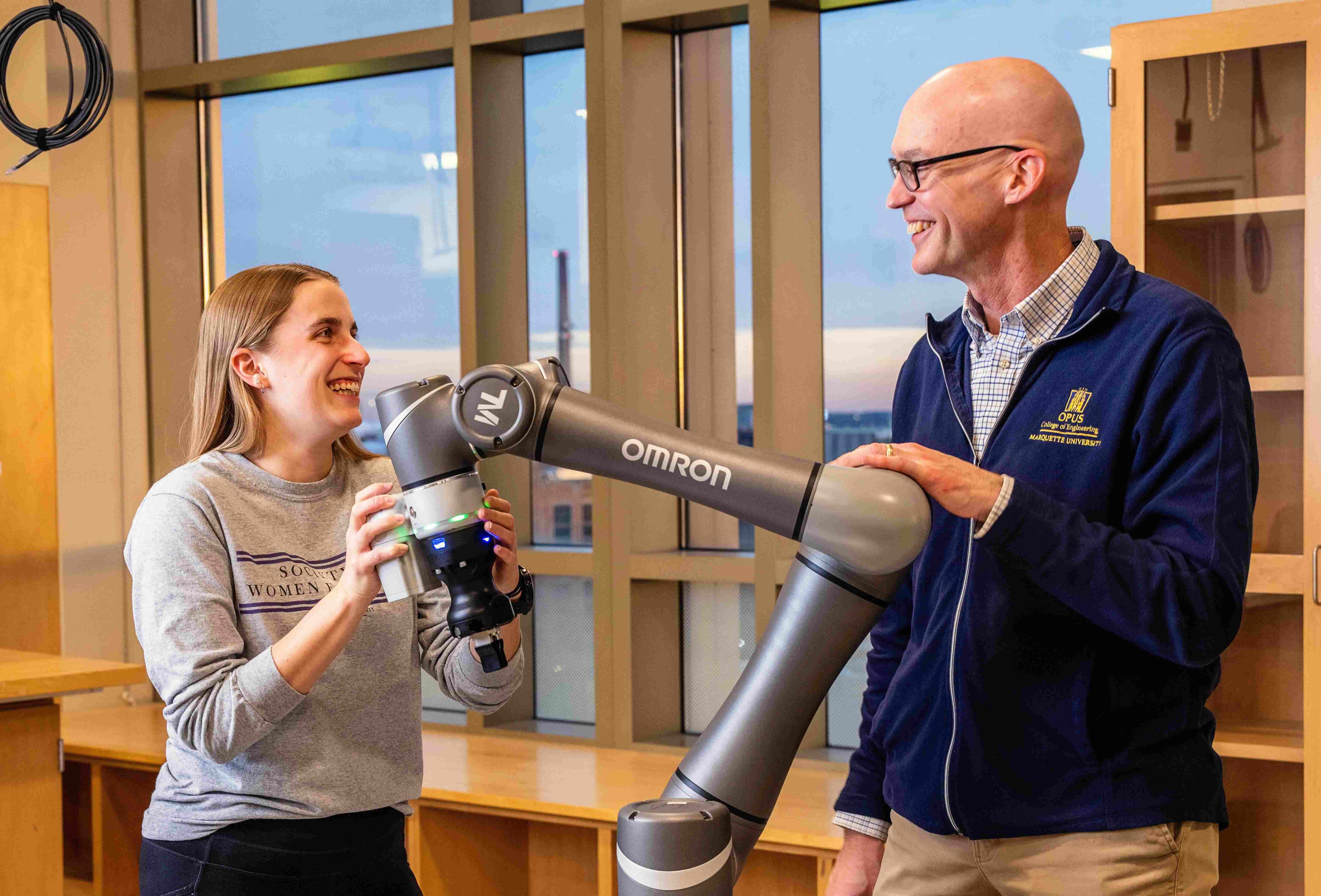 Student and Professor working with robotic arm