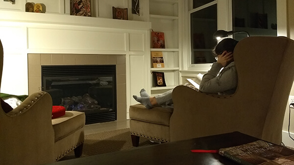 People reading in the lounge by the fireplace