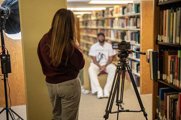 Student filming someone in a library