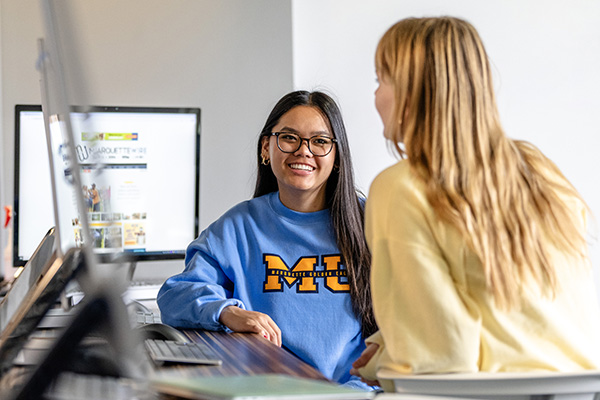 Two students working together by their computers