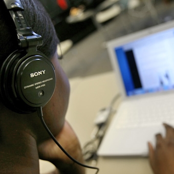 Student wearing headphones on laptop