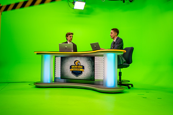 Two student broadcasters working on set