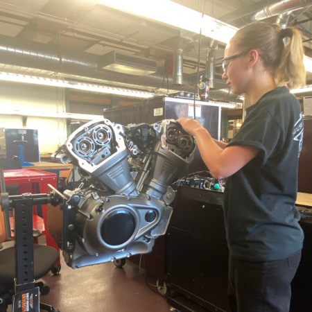 student working on a motorcycle engine