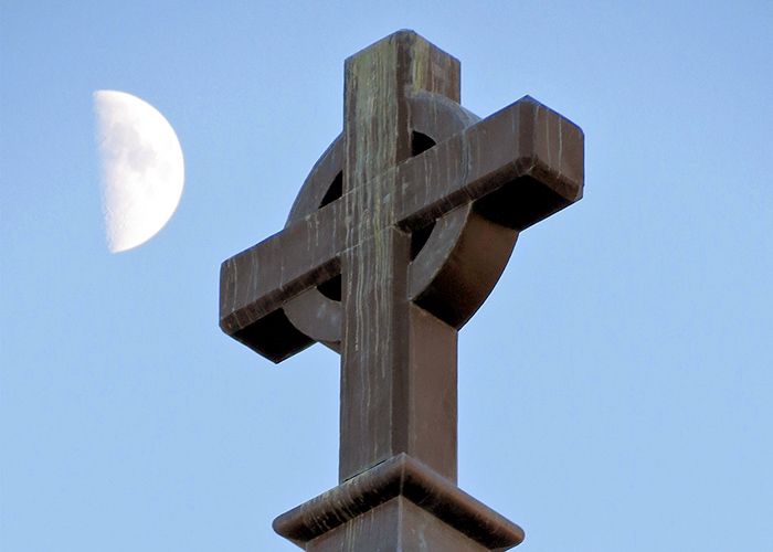 Cross on Gesu Church with a half moon in the sky