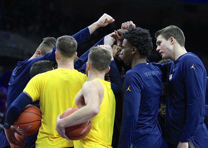 Men's basketball players in a huddle