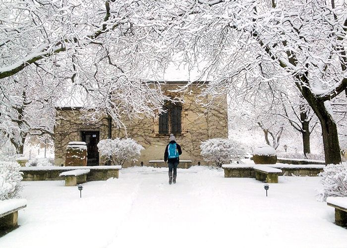 Student walks toward a snowy St. Joan of Arc Chapel