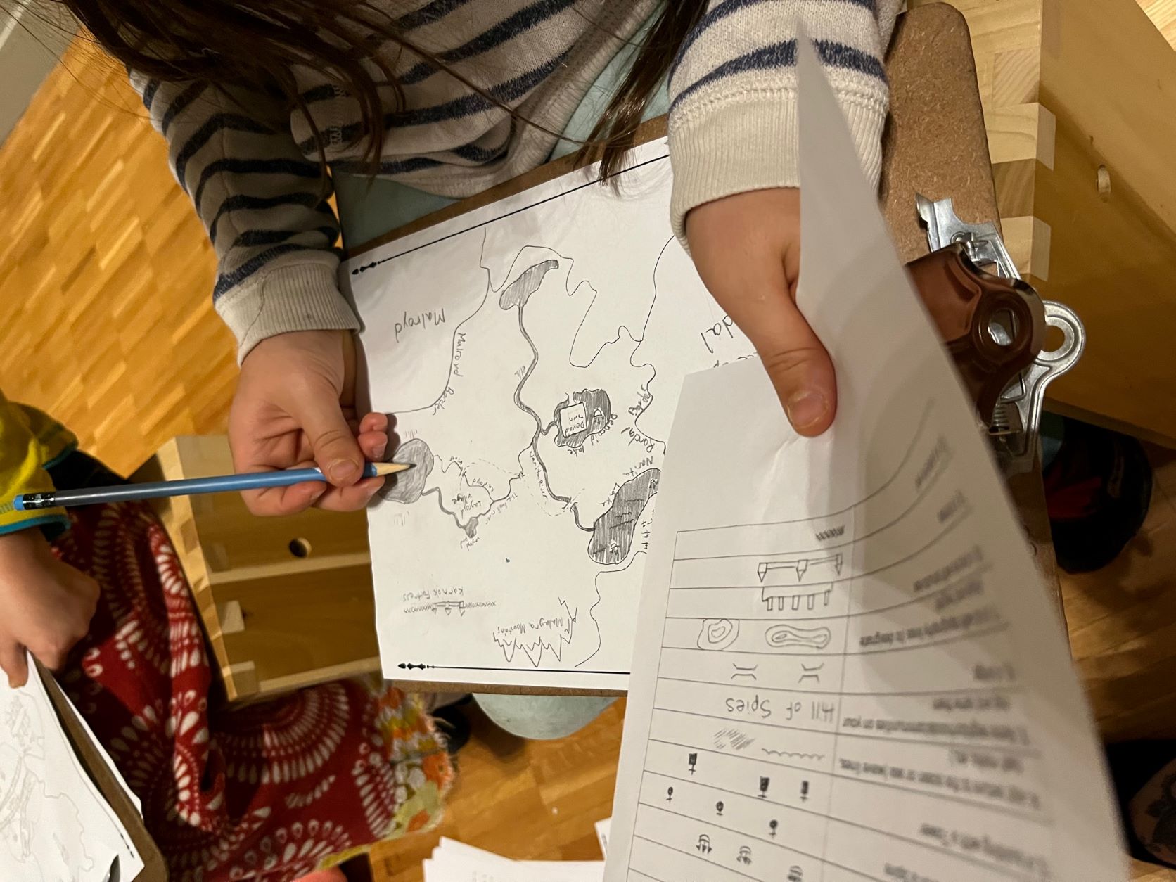 A child holds a map they are drawing