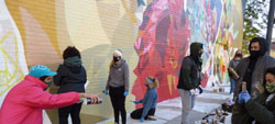 Marquette students help paint the mural "Our Roots Say That We're Sisters