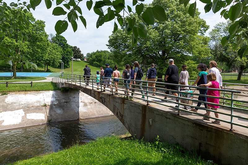 Residents walking across a bridge at Pulaski Park.