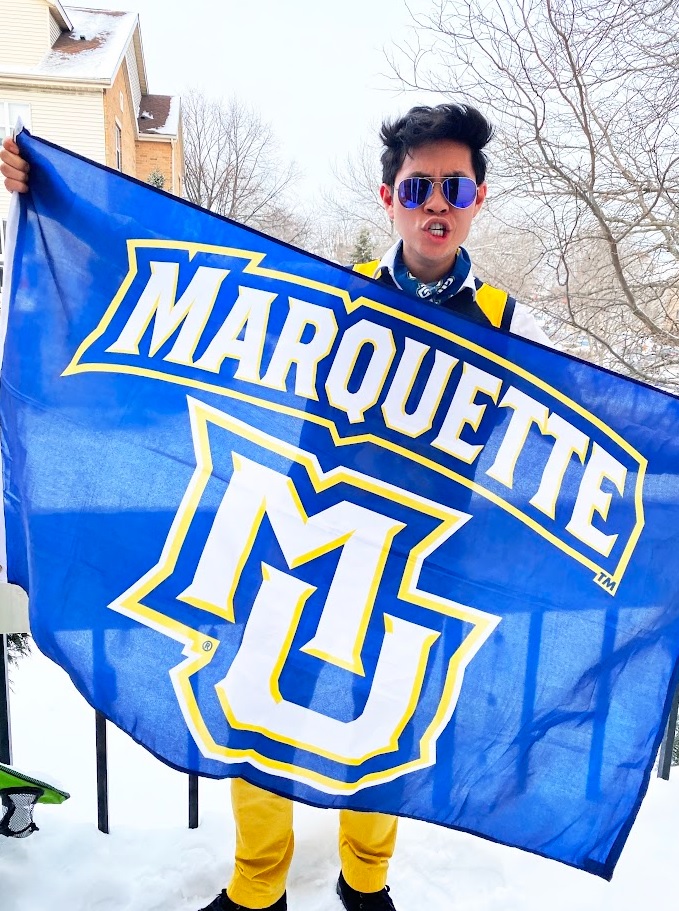 Individual holding a Marquette University flag
