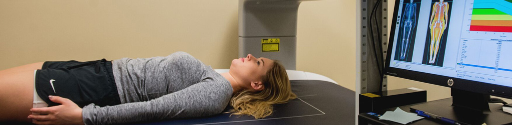 Woman being laying down having her vitals scanned by a computer.