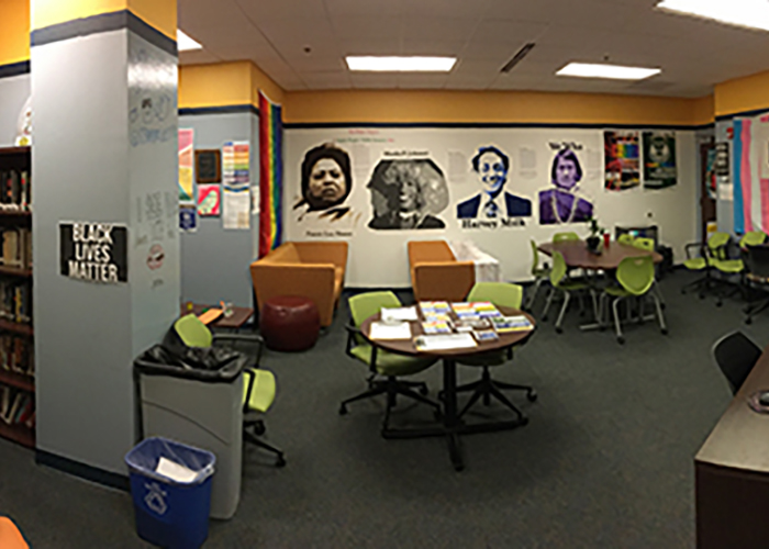 Interior of the Resource Center showing tables, chairs, and a mural on the wall.