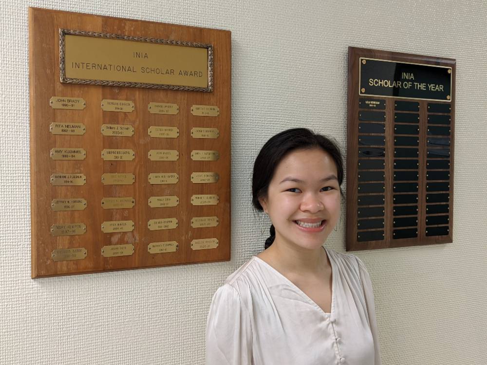 Lilli Kenfield standing between two award plaques. 