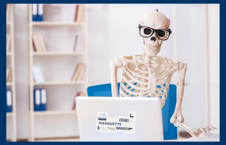 skeleton typing at a laptop