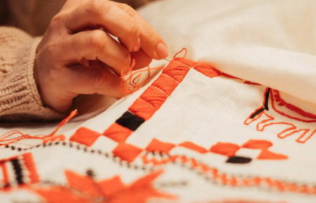closeup of a hand embroidering a cloth