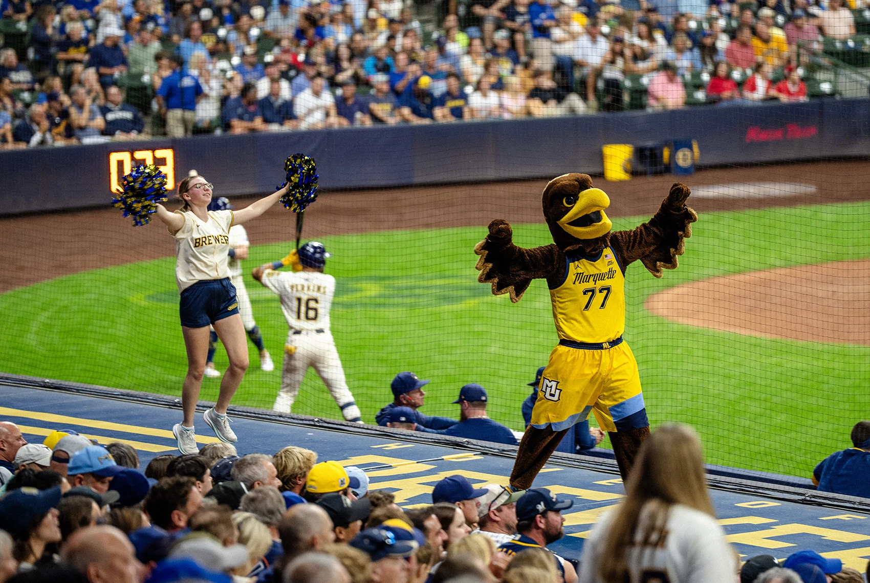 Iggy cheering with cheerleaders at brewers game