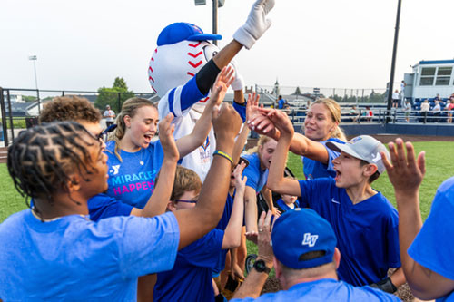 students play baseball with teens as part of the miracle league