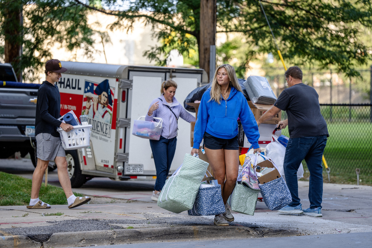 A student and her family moving her items into a residence hall