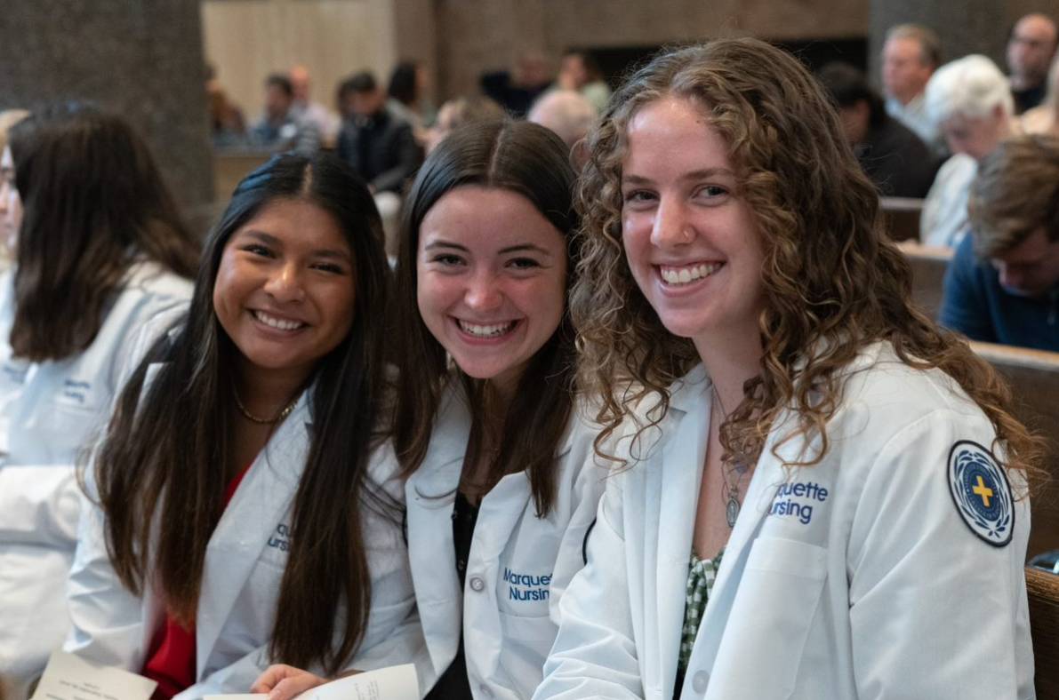 Three MU nursing students sit together at the 2022 Commitment to the Profession ceremony.