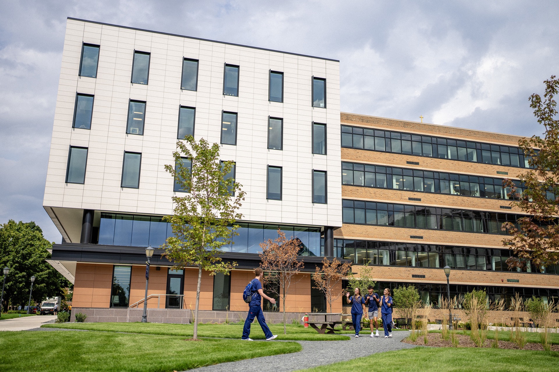 Nursing students walk by Straz Hall, the home of the College of Nursing.