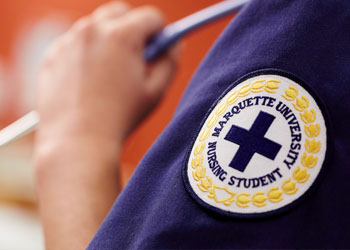 Nursing student wearing uniform showing patch