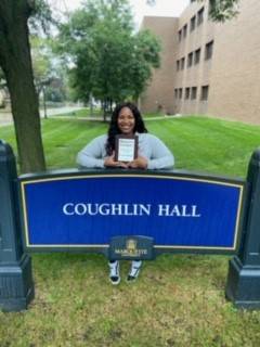 Student Employee of the Year, Taylor Housing, holding her award outside.