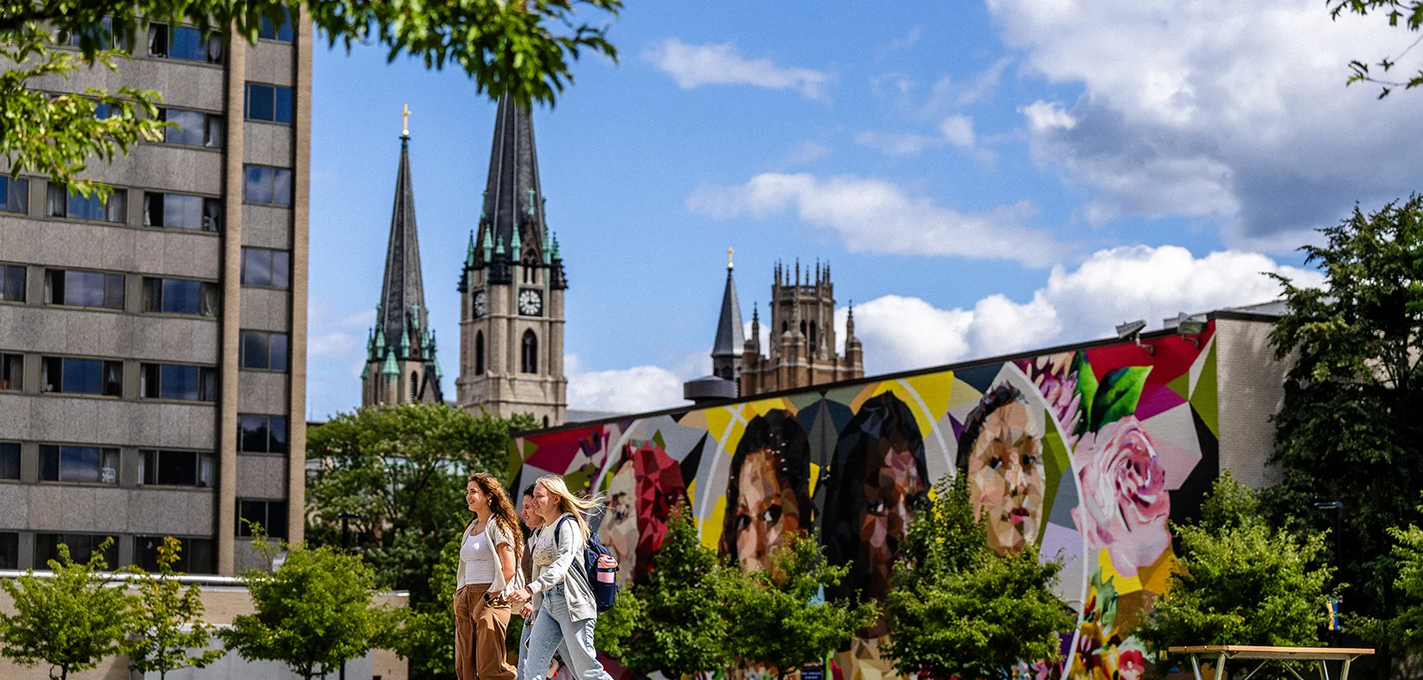 Marquette students walking by mural