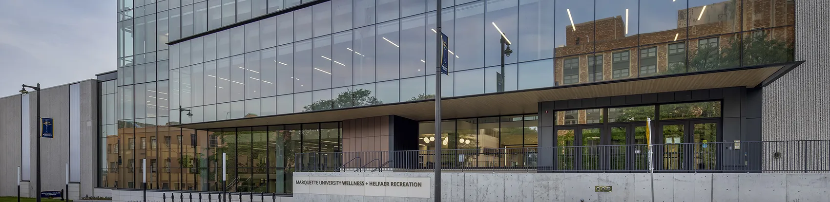 Man on a row machine with people standing near by. 